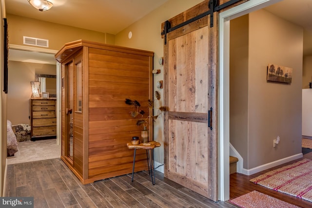 bathroom featuring wood finished floors, baseboards, and a relaxing sauna