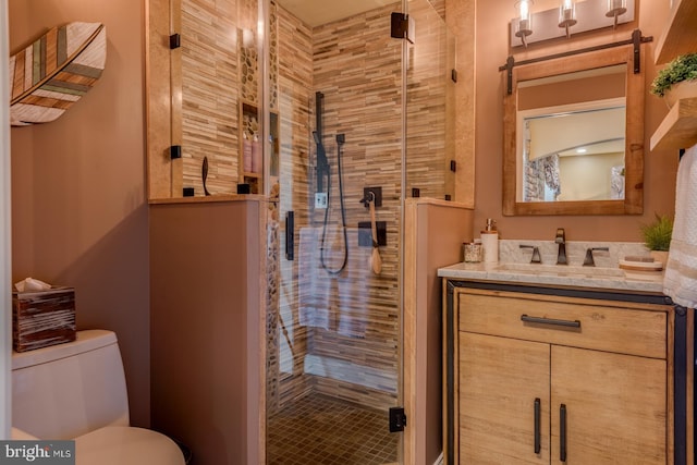 bathroom with a shower stall, toilet, and vanity