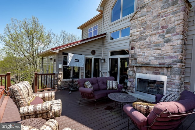 wooden deck with an outdoor living space with a fireplace