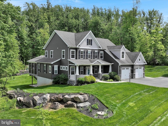 226 Crimson Ln, Elizabethtown, PA 17022 - view of front of house featuring covered porch, asphalt driveway, a garage, a front lawn, and a wooded view
