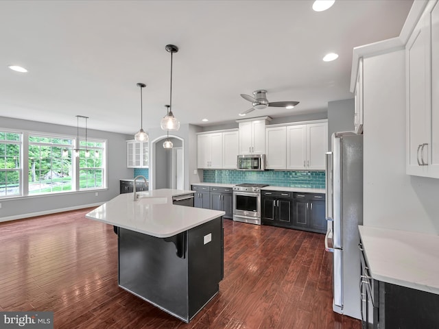 226 Crimson Ln, Elizabethtown, PA 17022 - kitchen with appliances with stainless steel finishes, light countertops, a kitchen island with sink, backsplash, and white cabinetry