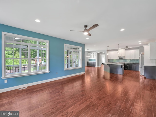 226 Crimson Ln, Elizabethtown, PA 17022 - unfurnished living room featuring ceiling fan, dark wood-style floors, arched walkways, baseboards, and recessed lighting
