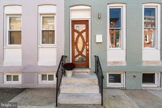 view of exterior entry featuring brick siding