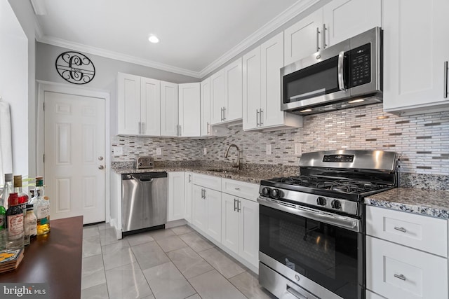 kitchen featuring appliances with stainless steel finishes, ornamental molding, a sink, and white cabinetry