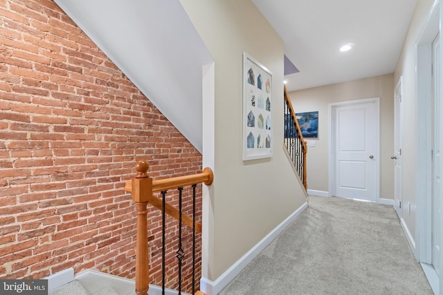 corridor featuring baseboards, carpet flooring, brick wall, an upstairs landing, and recessed lighting