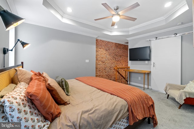 carpeted bedroom featuring a tray ceiling, ornamental molding, ceiling fan, recessed lighting, and a barn door