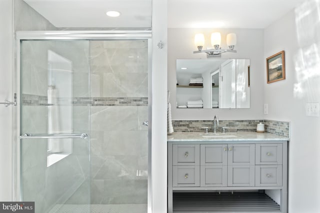 bathroom with a stall shower, vanity, backsplash, and recessed lighting