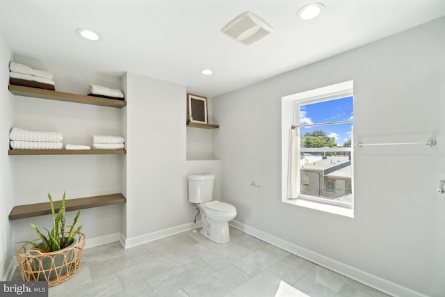 bathroom featuring baseboards, toilet, and recessed lighting