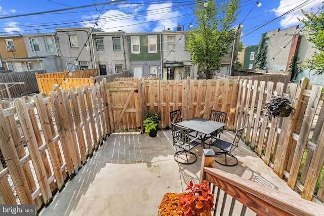 view of patio with a fenced backyard, a gate, and outdoor dining space