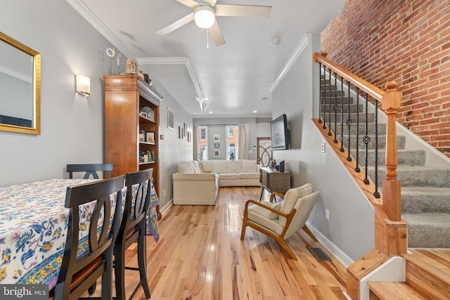 living area featuring light wood-style floors, stairs, ceiling fan, ornamental molding, and baseboards