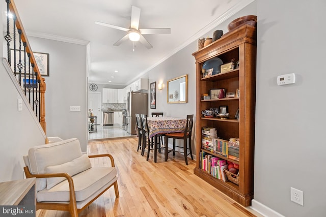 living area with ornamental molding, ceiling fan, light wood finished floors, stairway, and recessed lighting