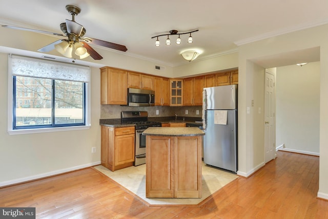 146 Monroe St Unit 101, Rockville, MD 20850 - kitchen featuring stainless steel appliances, light wood-style flooring, ceiling fan, glass insert cabinets, and backsplash