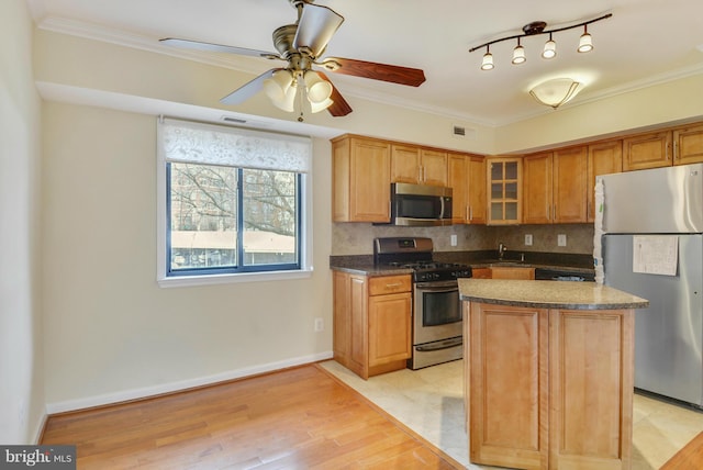 146 Monroe St Unit 101, Rockville, MD 20850 - kitchen with appliances with stainless steel finishes, a sink, glass insert cabinets, decorative backsplash, and a center island