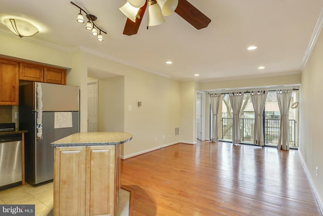 146 Monroe St Unit 101, Rockville, MD 20850 - kitchen featuring stainless steel appliances, a ceiling fan, a kitchen island, light wood finished floors, and ornamental molding