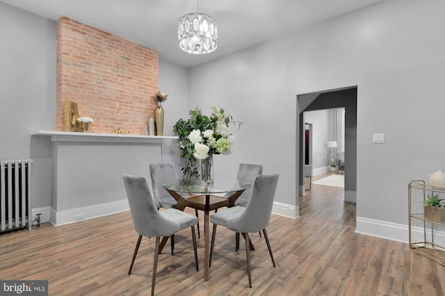 702 N Arlington Ave, Baltimore, MD 21217 - dining space featuring radiator heating unit, wood finished floors, a chandelier, and baseboards
