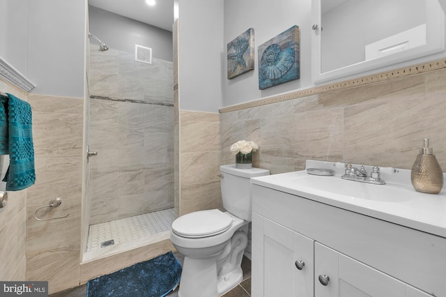 702 N Arlington Ave, Baltimore, MD 21217 - bathroom with a stall shower, toilet, tile walls, vanity, and a wainscoted wall