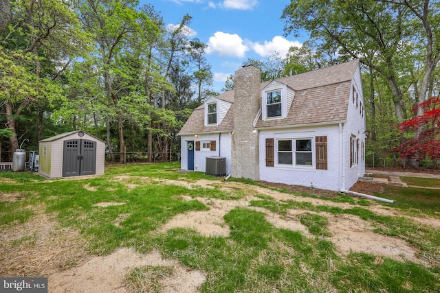 702 Lupin St, Browns Mills, NJ 08015 - rear view of house featuring central air condition unit, a storage unit, a chimney, an outdoor structure, and a shingled roof