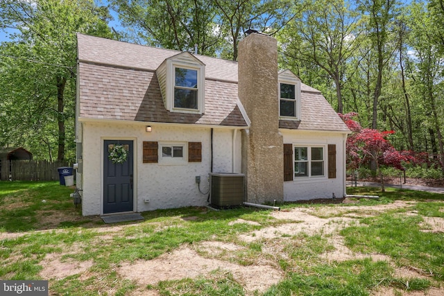 702 Lupin St, Browns Mills, NJ 08015 - back of property with a chimney, central AC unit, stucco siding, roof with shingles, and fence
