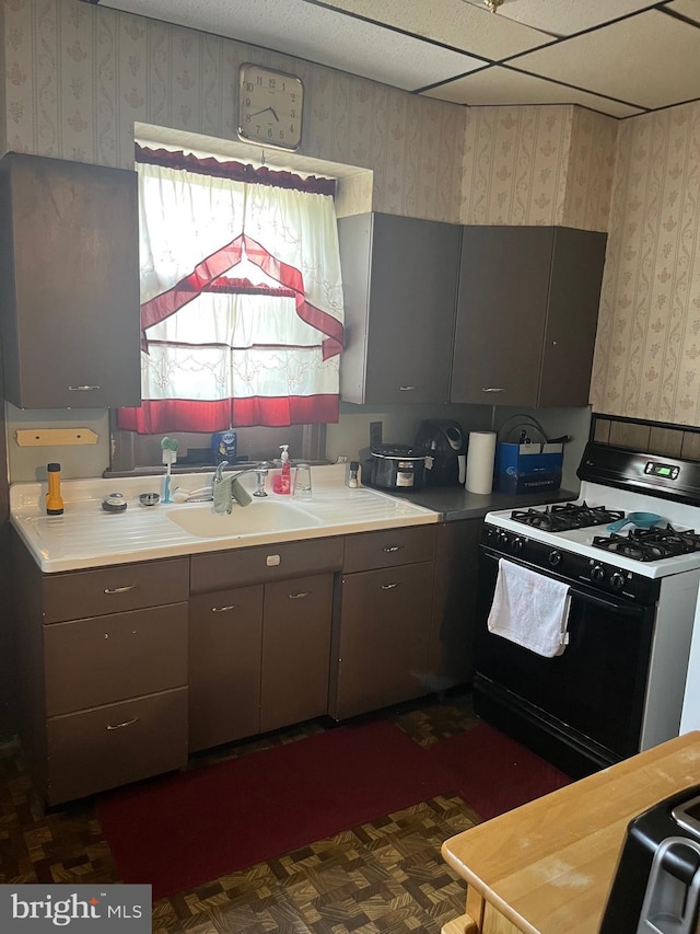5721 N Lawrence St, Philadelphia, PA 19120 - kitchen featuring gas range, wallpapered walls, a sink, gray cabinetry, and light countertops