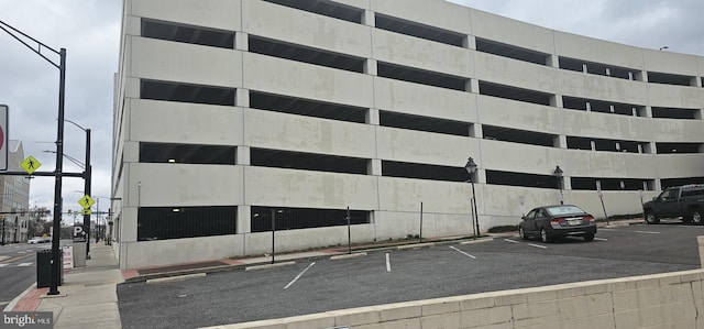 view of property featuring uncovered parking and fence