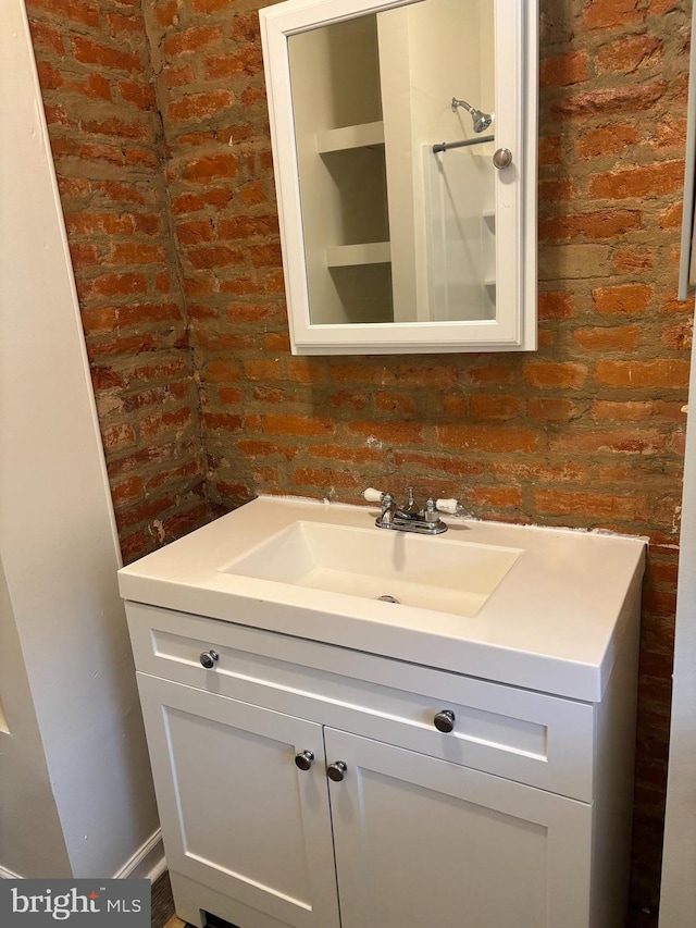 bathroom with brick wall and vanity