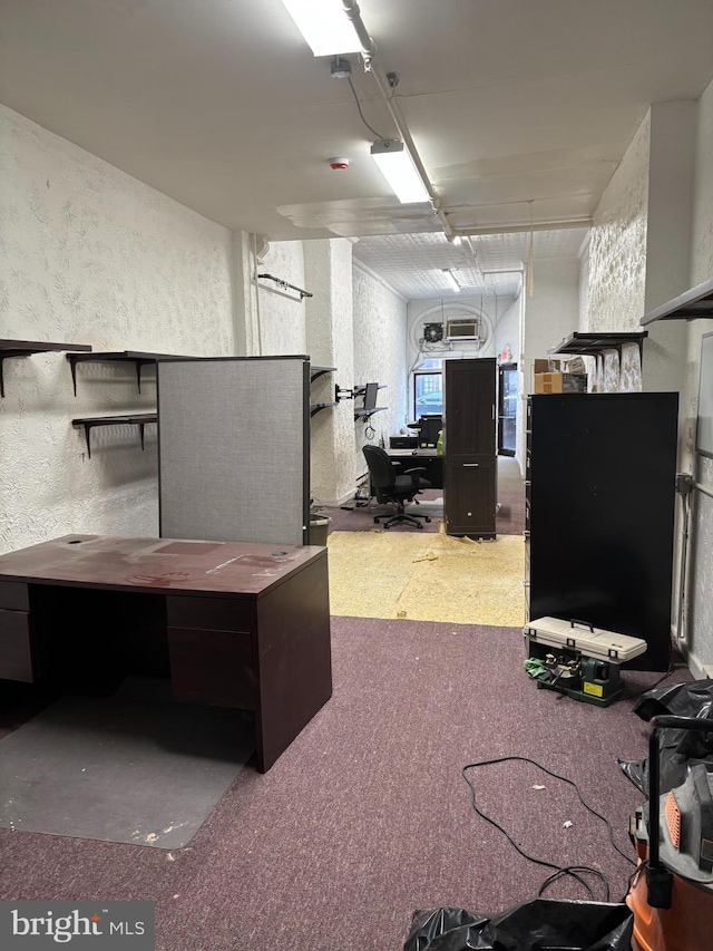 basement with a textured wall, carpet flooring, and a desk