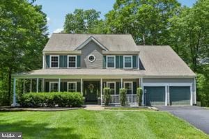 11050 Stonebrook Dr, Manassas, VA 20112 - colonial inspired home featuring covered porch, a garage, driveway, and a front yard