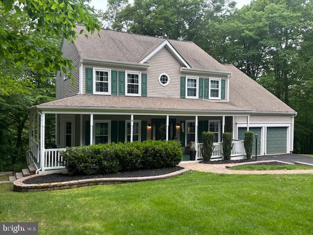 11050 Stonebrook Dr, Manassas, VA 20112 - colonial home with covered porch, driveway, an attached garage, and a front lawn