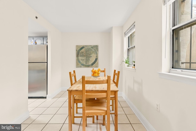 dining space with light tile patterned floors and baseboards