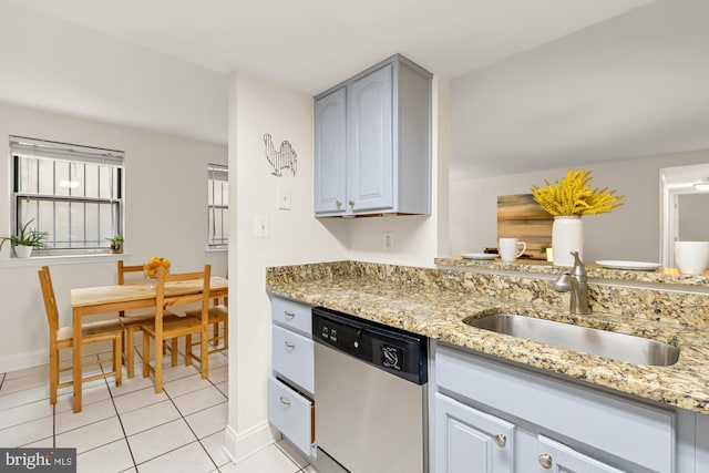 kitchen with dishwasher, a sink, light tile patterned floors, light stone counters, and baseboards