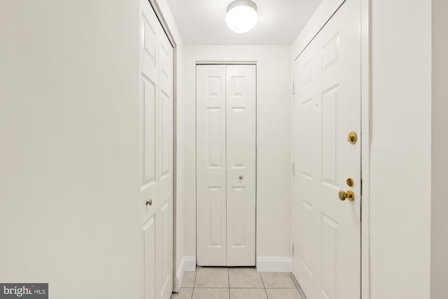 doorway to outside featuring light tile patterned floors and baseboards