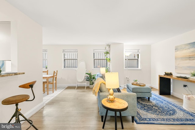 living area with light wood-style flooring and baseboards