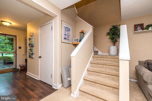 staircase featuring baseboards and wood finished floors