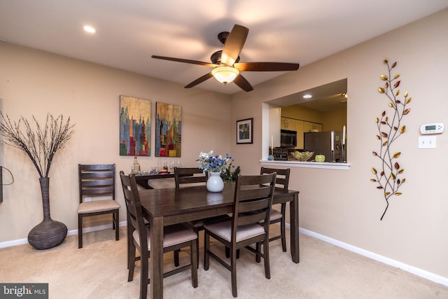 dining room featuring light colored carpet, a ceiling fan, baseboards, and recessed lighting