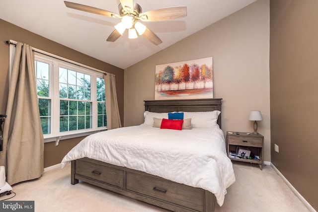 bedroom featuring light carpet, lofted ceiling, baseboards, and ceiling fan
