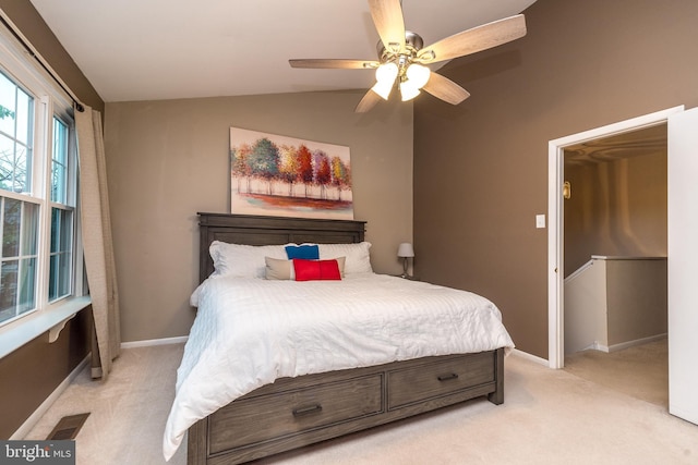 bedroom with light colored carpet, vaulted ceiling, baseboards, and ceiling fan