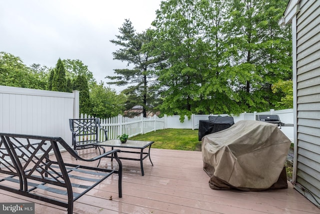 wooden deck featuring a grill and outdoor dining space