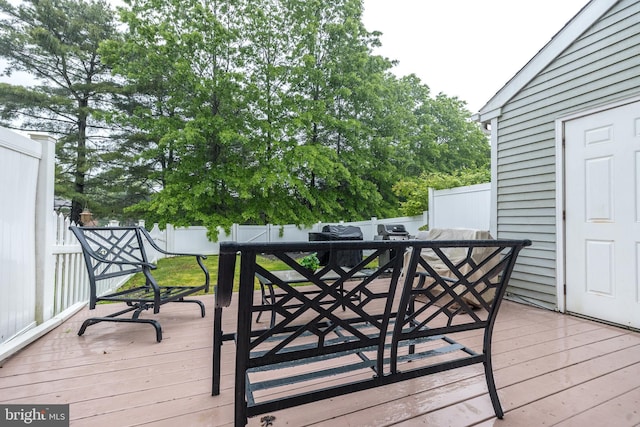wooden terrace featuring outdoor dining space and a fenced backyard
