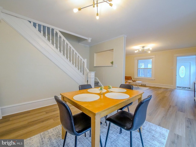 1008 Mcclenahan Ter, Marcus Hook, PA 19061 - dining space with stairway, light wood-style floors, baseboards, and a chandelier