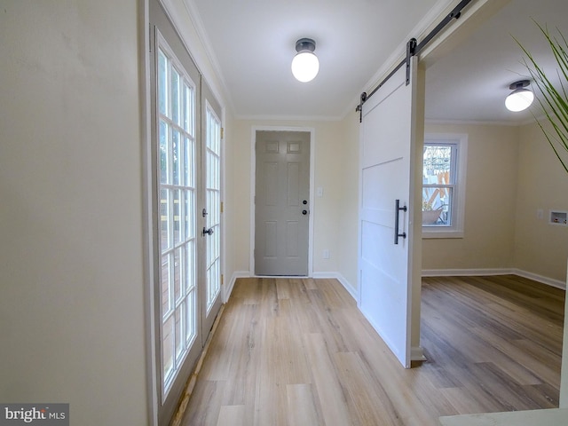1008 Mcclenahan Ter, Marcus Hook, PA 19061 - entryway with a barn door, light wood finished floors, crown molding, and baseboards