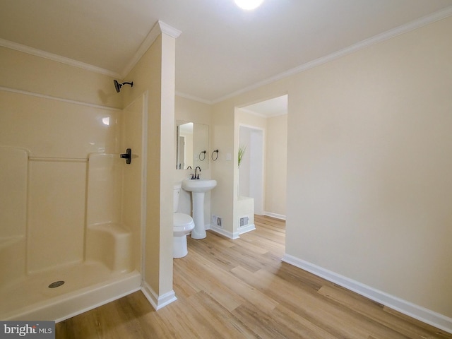 1008 Mcclenahan Ter, Marcus Hook, PA 19061 - bathroom featuring wood finished floors, a shower, crown molding, baseboards, and toilet