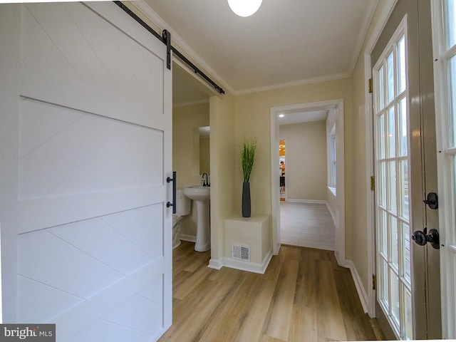 1008 Mcclenahan Ter, Marcus Hook, PA 19061 - corridor with a barn door, light wood finished floors, baseboards, crown molding, and a sink