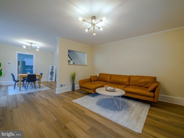 1008 Mcclenahan Ter, Marcus Hook, PA 19061 - living room with a chandelier, wood finished floors, crown molding, and baseboards