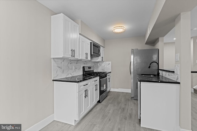 9001 Ridge Ave Unit 14, Philadelphia, PA 19128 - kitchen with appliances with stainless steel finishes, dark countertops, baseboards, and white cabinetry
