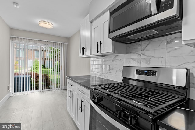 9001 Ridge Ave Unit 14, Philadelphia, PA 19128 - kitchen featuring stainless steel appliances, white cabinetry, decorative backsplash, and baseboards