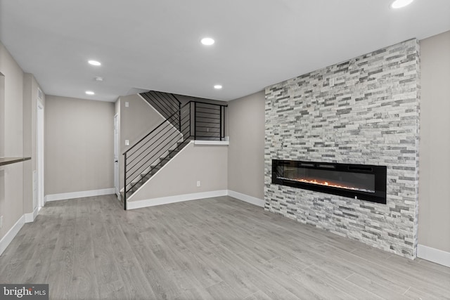 9001 Ridge Ave Unit 14, Philadelphia, PA 19128 - unfurnished living room featuring wood finished floors, stairs, recessed lighting, baseboards, and a large fireplace
