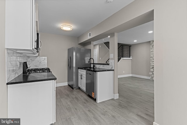9001 Ridge Ave Unit 14, Philadelphia, PA 19128 - kitchen with stainless steel appliances, dark countertops, white cabinetry, tasteful backsplash, and baseboards