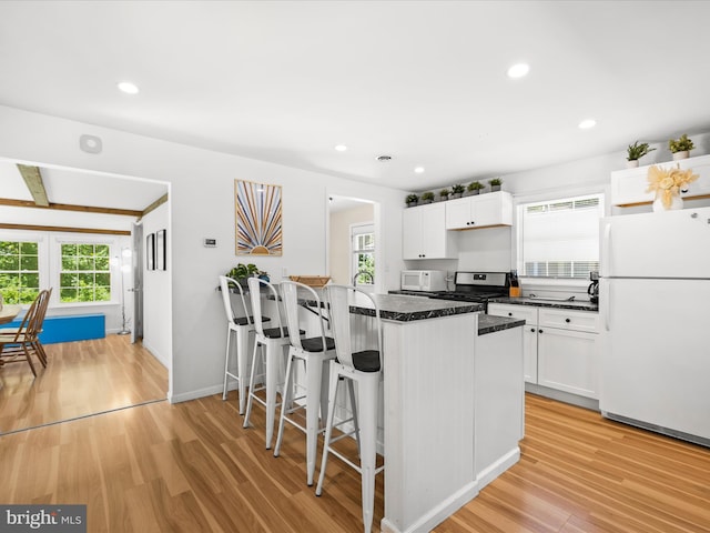 kitchen with white appliances, plenty of natural light, light wood-style flooring, and recessed lighting