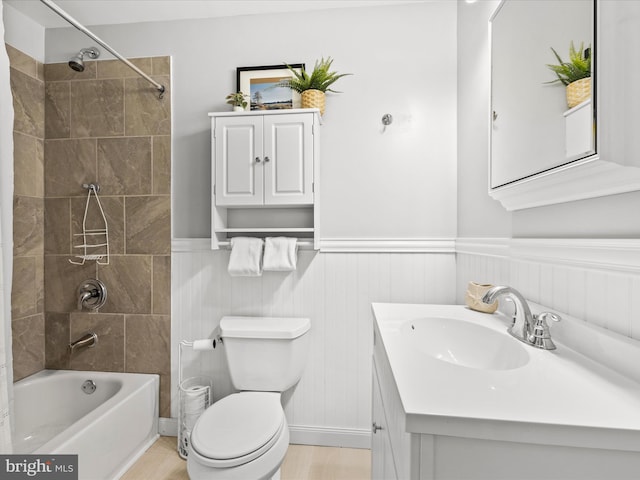 full bath with a wainscoted wall, shower / tub combination, vanity, and toilet