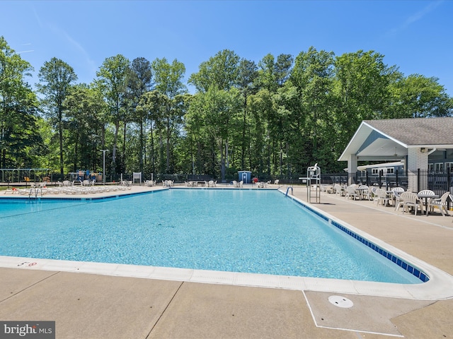 community pool featuring fence and a patio area